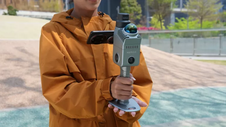 Operator walking a site with a handheld SLAM LiDAR scanner